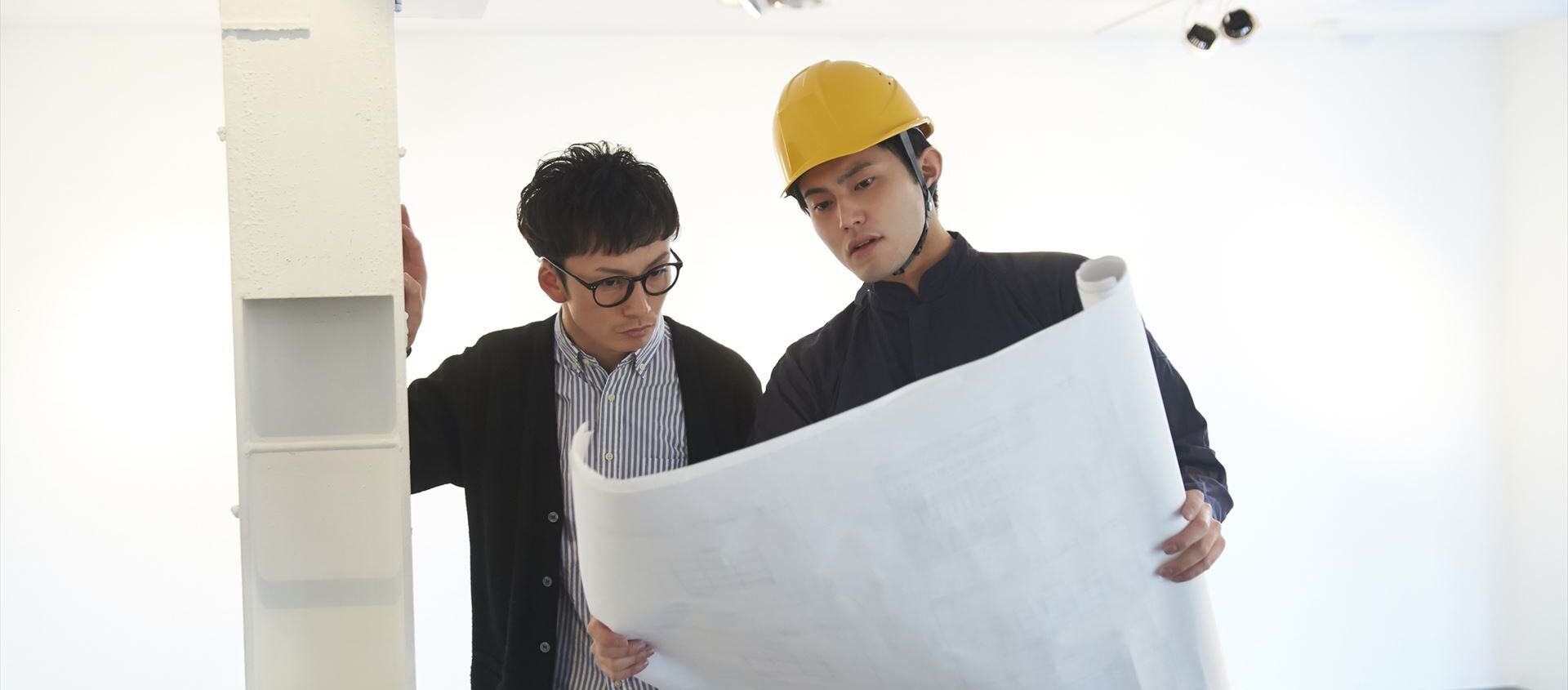 現場で打ち合わせする設計士