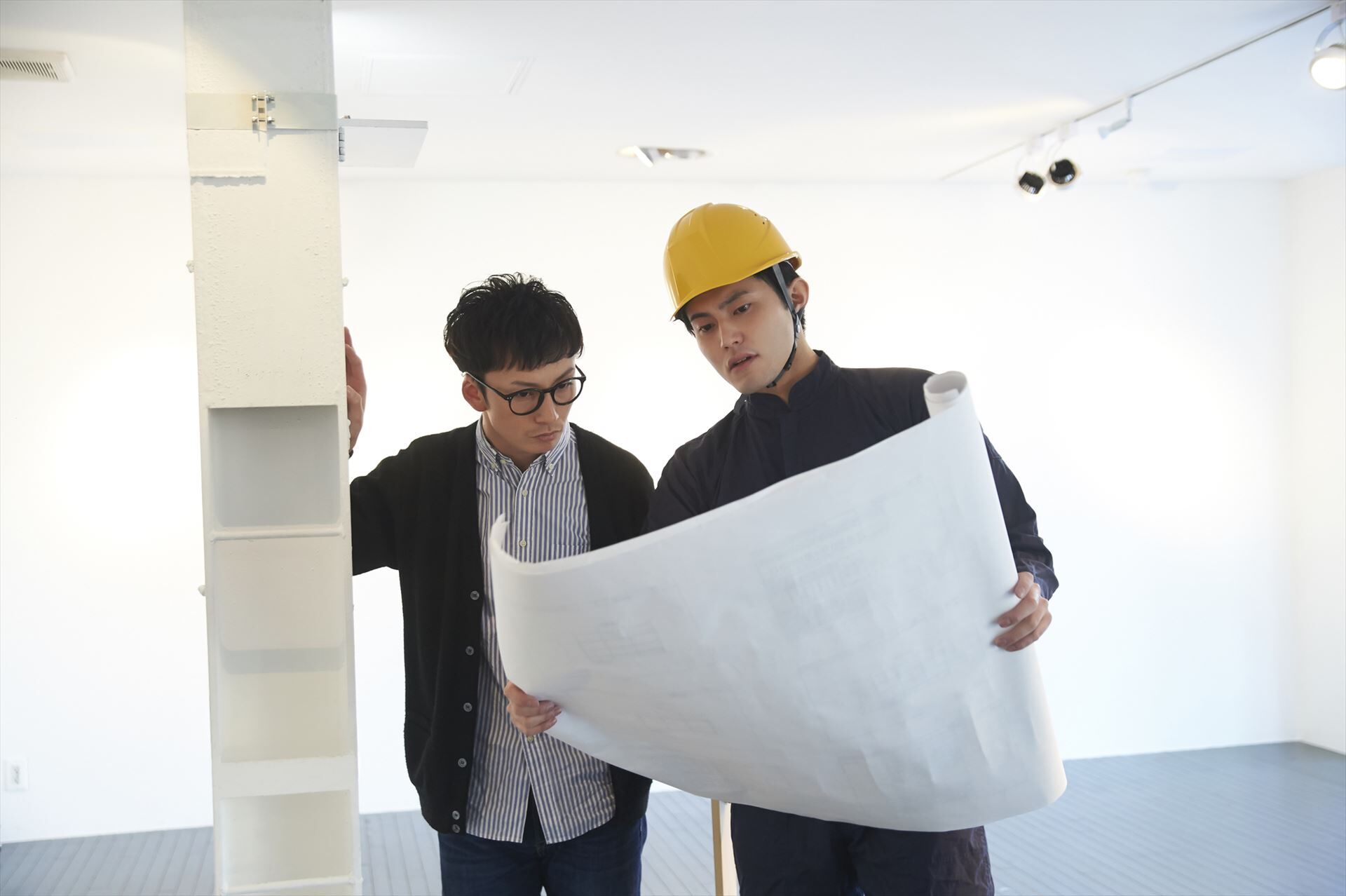 現場で打ち合わせする設計士